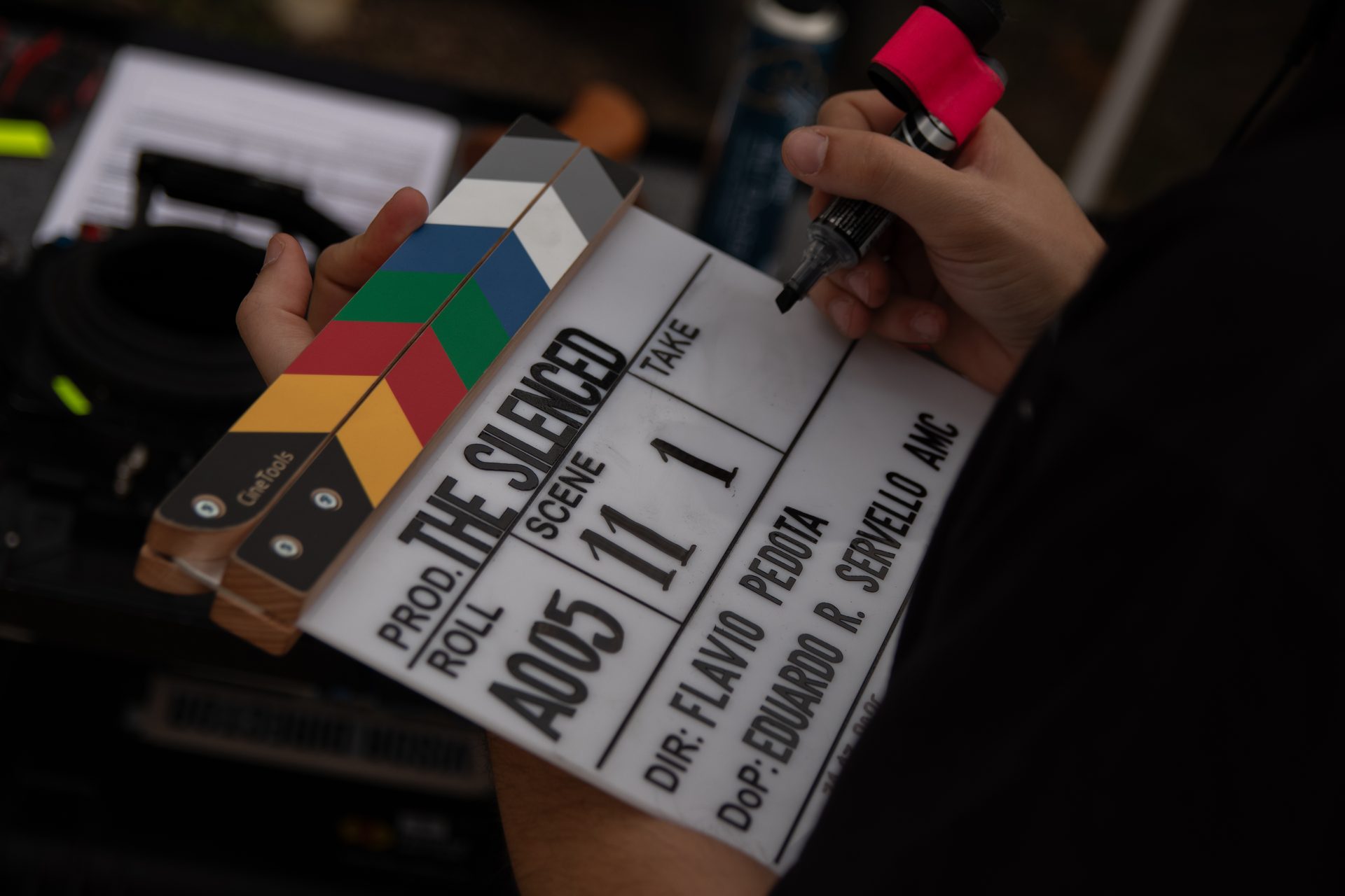 Hand marking the slate of The Silenced — directed by Flavio Pedota, cinematography by Eduardo R. Servello AMC